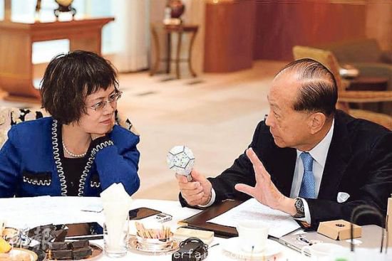 李嘉誠（右）在接受媒體訪問時指出，長實集團以香港為基地，常常積極在港尋找投資機會，但是政府很多政策，需時消化。圖為他向財新傳媒總編輯胡舒立介紹他本周的“最愛”納米LED燈泡。圖片來源：香港明報